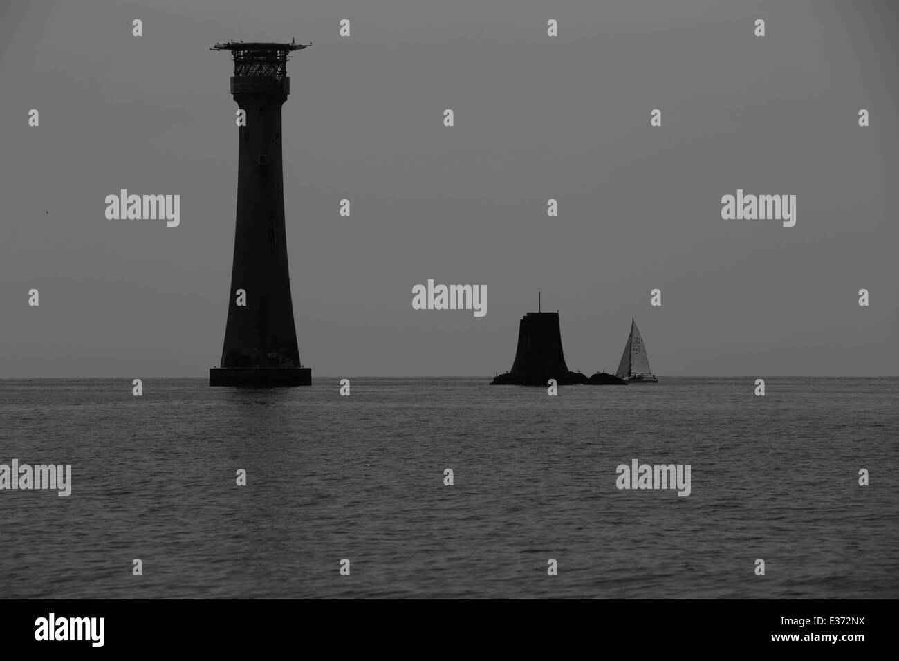 Einsame Yacht vorbei Eddystone Leuchtturm Plymouth Uk während Nächstenliebe Verfolgung in schwarz / weiß Stockfoto