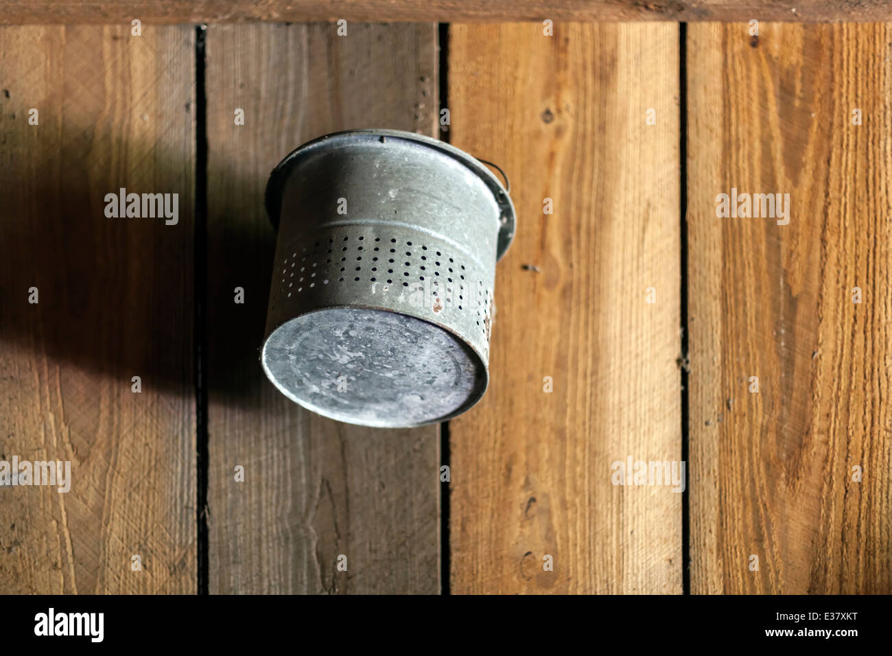 Alte verzinkte Stahl-Eimer oder Eimer hängt an die Holzwand einer alten Scheune. USA Stockfoto