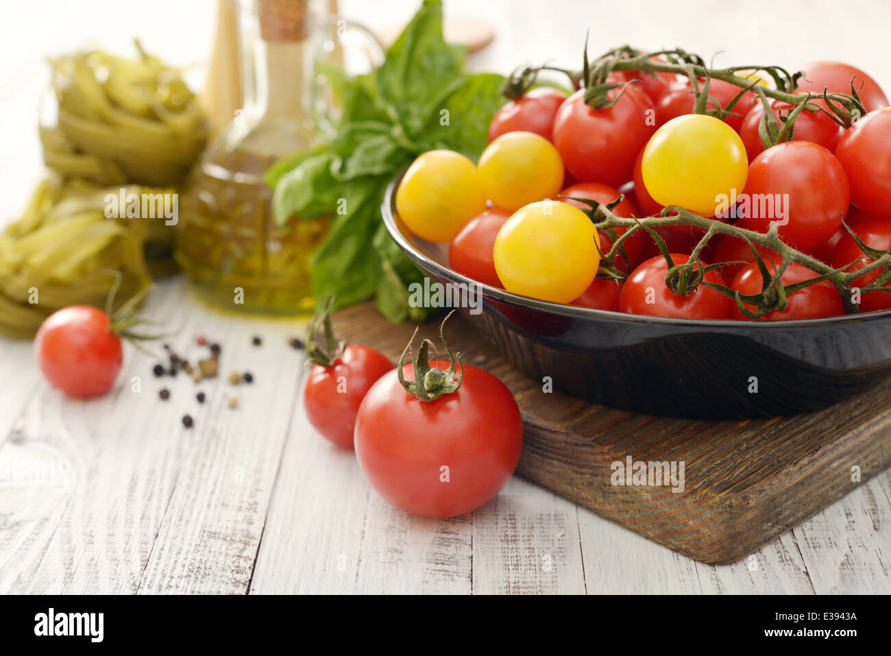 Frische reife Tomate auf Platte, Olivenöl und Basilikum auf hölzernen Hintergrund Stockfoto