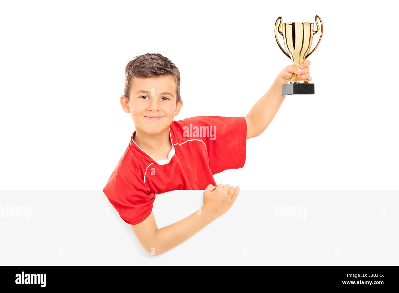 Junior Sportler halten eine Trophäe hinter einer Blende Stockfoto