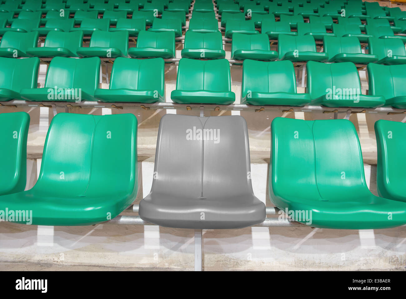 graue Stadion Sitz zwischen grünen Sitze Stockfoto