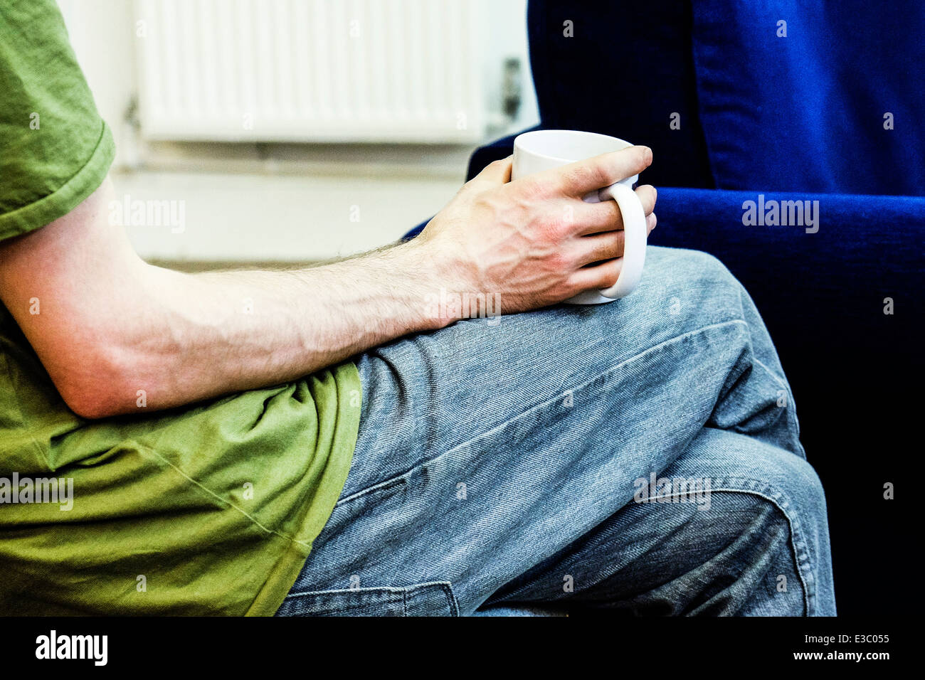 Ein Mann hält einen Becher während einer Kaffeepause. Stockfoto