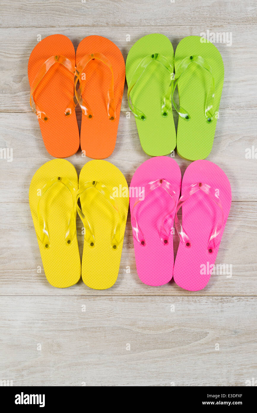 Vertikales Bild von vier Paaren neue Sandalen platziert auf Alter Holz Stockfoto