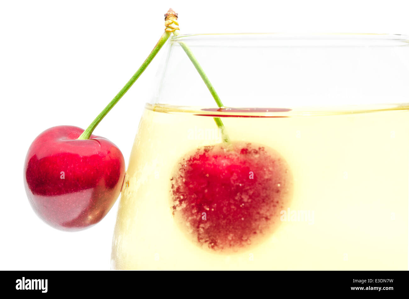 Paar Reifen Kirsche Beeren an Oberkante voll beschlagene Weinglas mit kalten weißen Wein isoliert Nahaufnahme Stockfoto