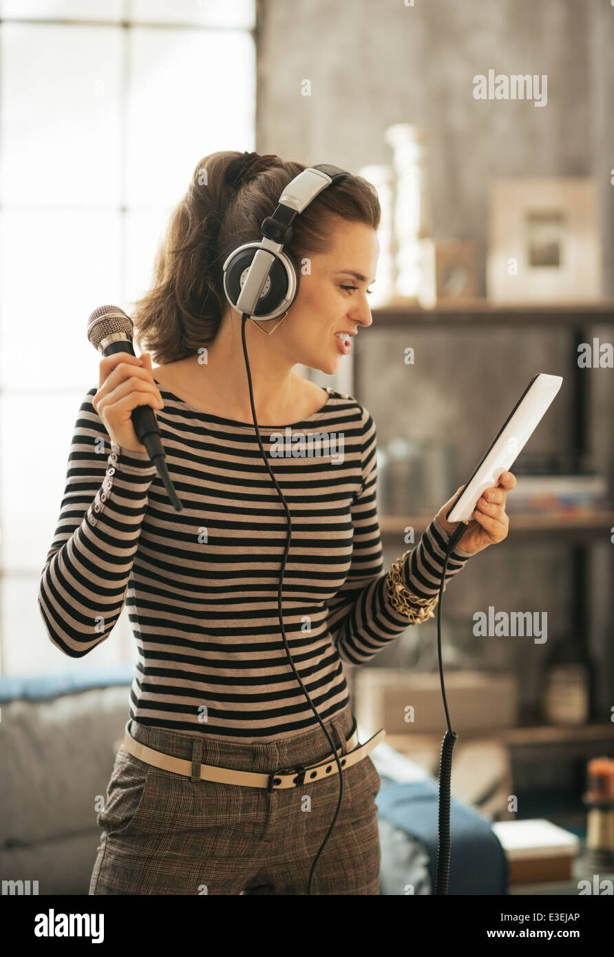 Junge Frau mit Tablet pc Karaoke singen Stockfoto