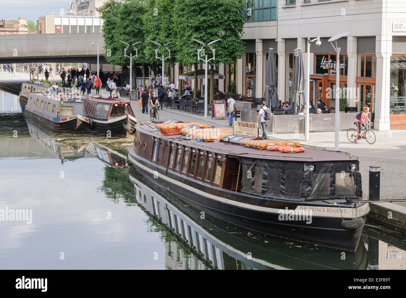 Kanalboote vertäut am Paddington Basin, neben hohen Bürogebäuden. Stockfoto