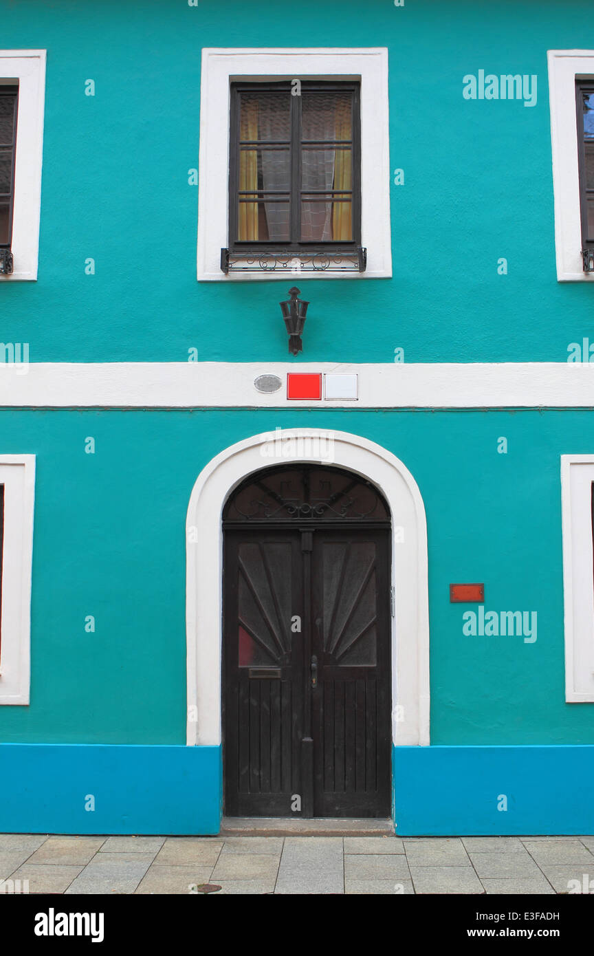 Fassade eines blau bemalten Hauses mit dunklen Tür und Fenster Stockfoto
