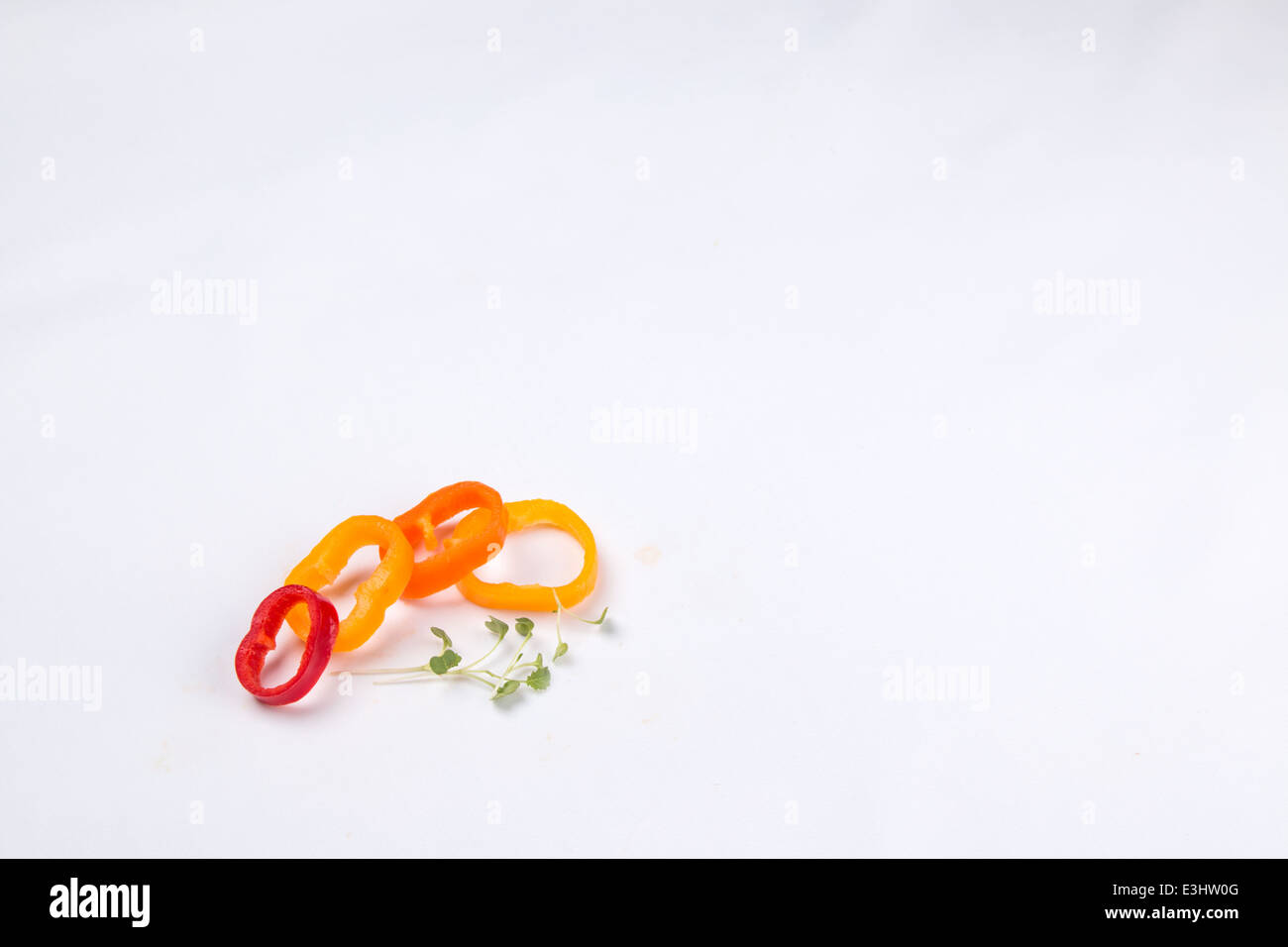Garnitur aus rot, orange und gelbe Paprika/Peperoni schneiden in 4 Ringe mit einer Prise Kresse (3of 3) Stockfoto