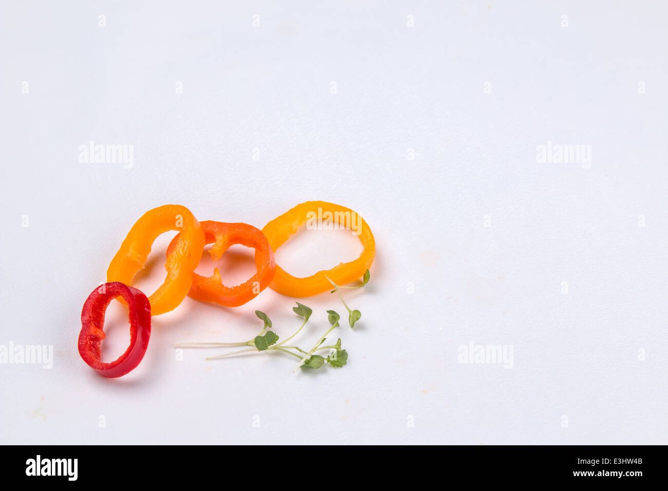 Garnitur aus rot, orange und gelbe Paprika? Paprika schneiden in 4 Ringe mit einer Prise Kresse (2 von 3) Stockfoto