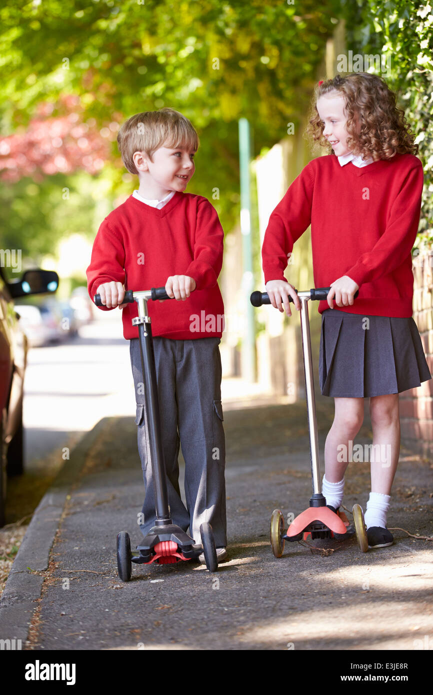 Jungen und Mädchen Motorroller auf dem Weg zur Schule Stockfoto