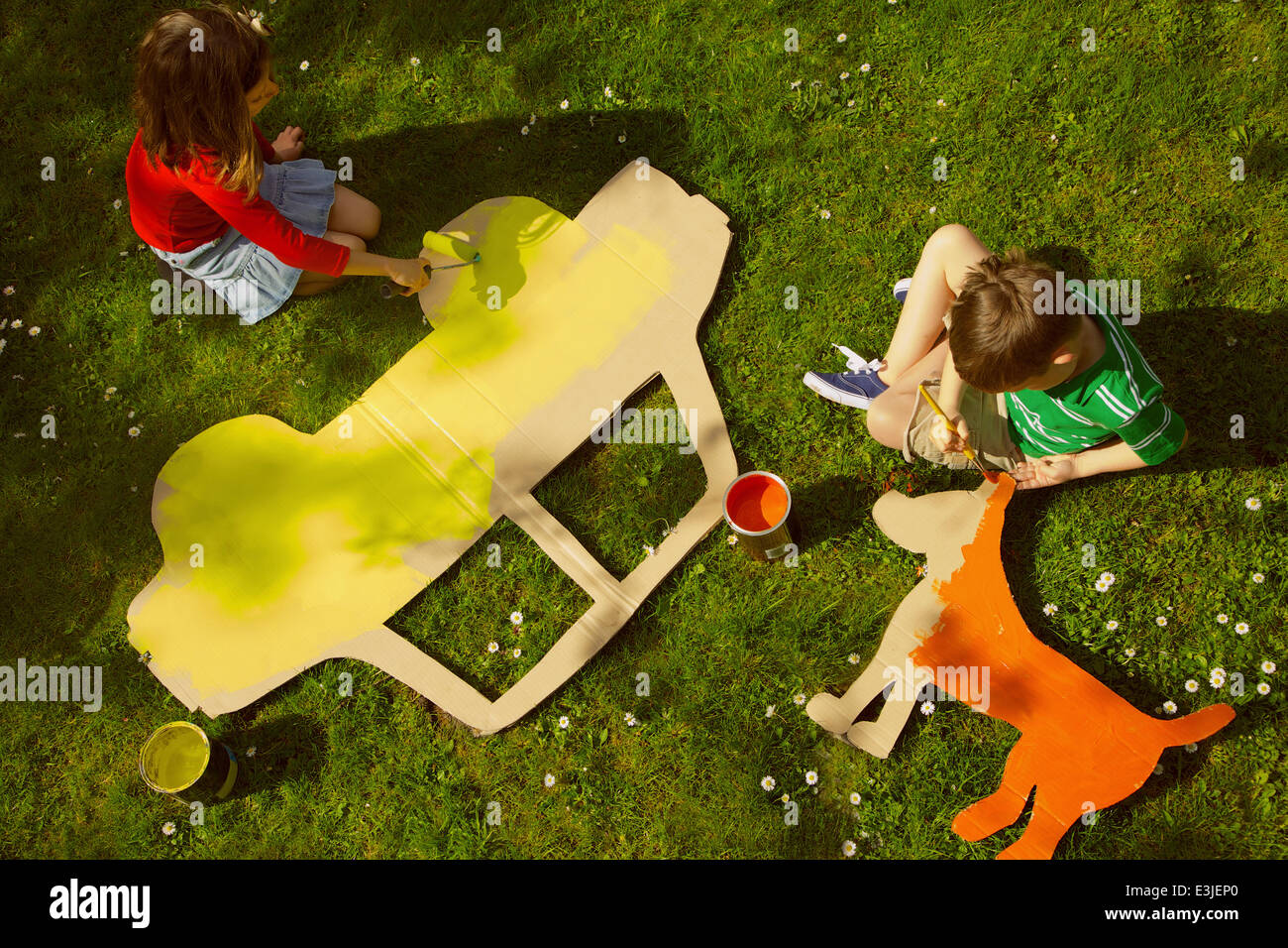 Kinder malen Karton Cut Outs im Garten Stockfotografie - Alamy