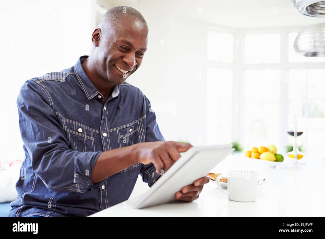 Afrikanische Amerikaner mit Digital-Tablette zu Hause Stockfoto