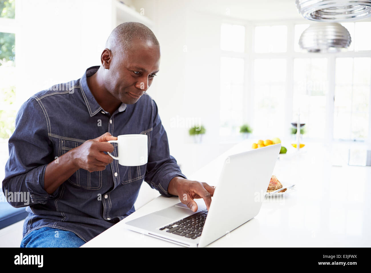 Afrikanische amerikanische Mann mit Laptop zu Hause Stockfoto