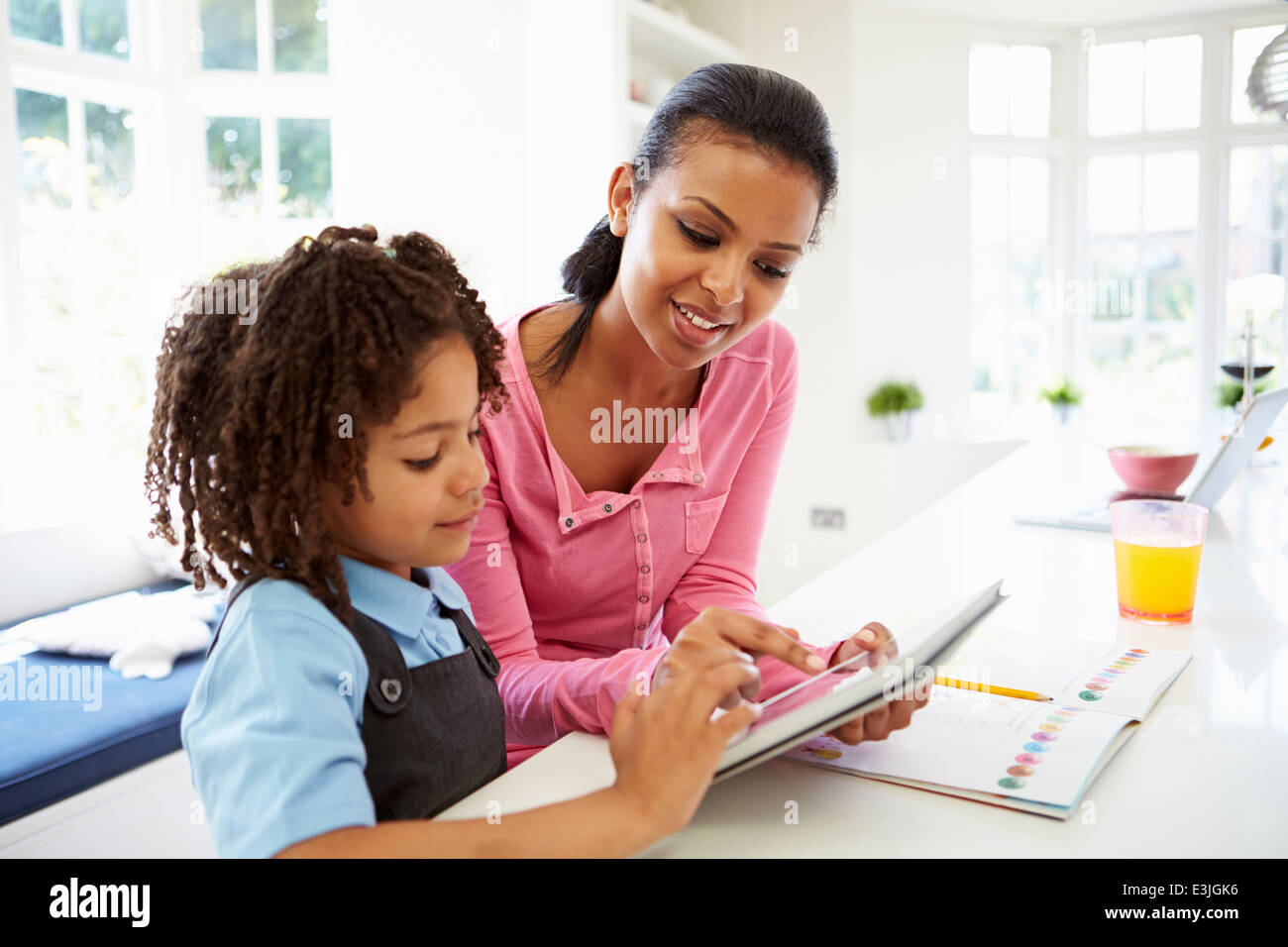 Mutter und Kind mit Digital-Tablette für Hausaufgaben Stockfoto
