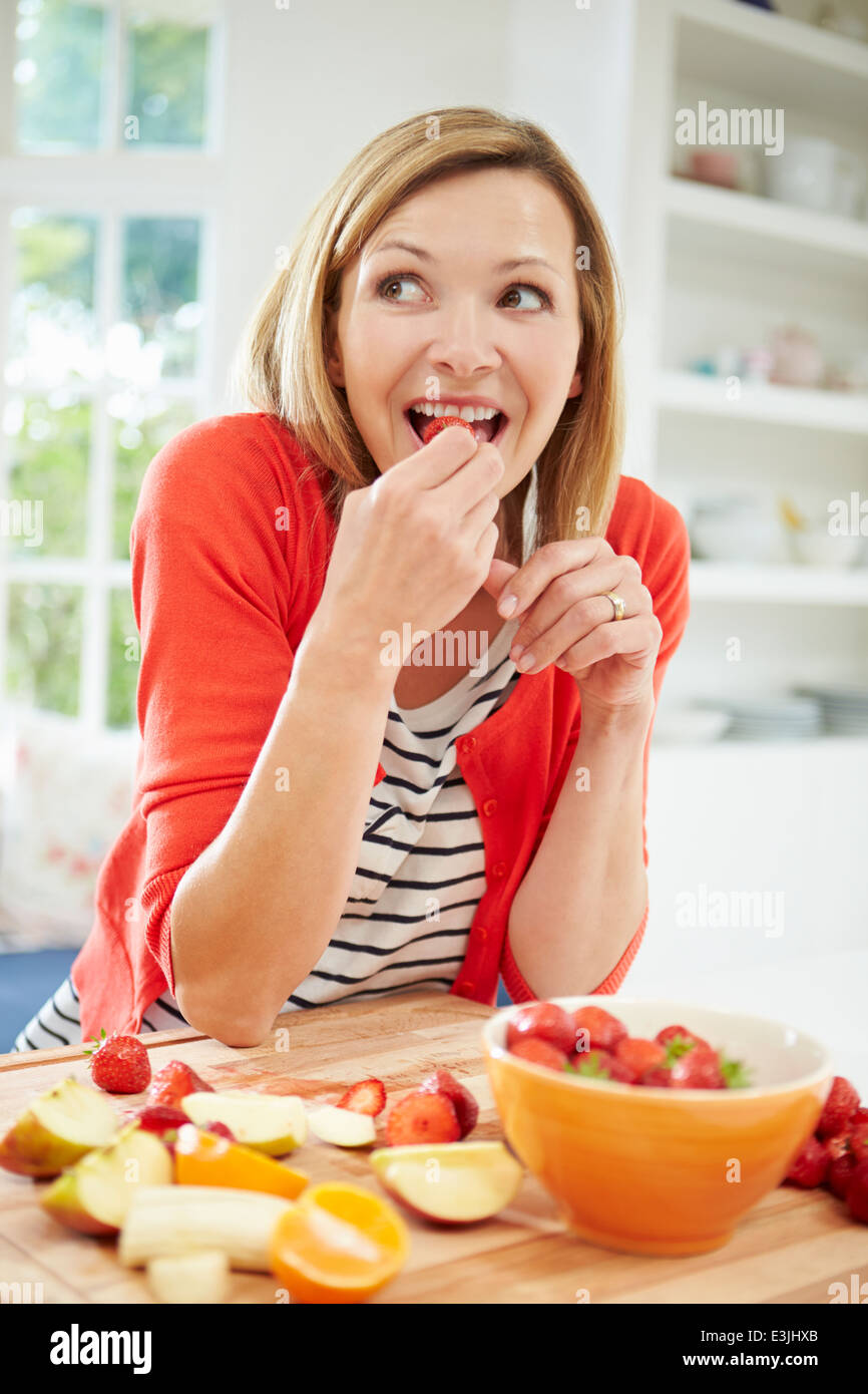 Frau Vorbereitung Obstsalat In Küche Stockfoto