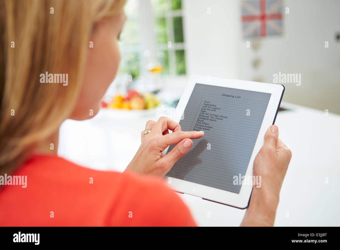 Frau mit Digital-Tablette, schreiben Einkaufszettel zu Hause Stockfoto