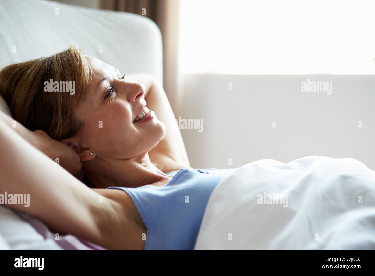 Attraktive applying Frau aufwachen im Bett Stockfoto