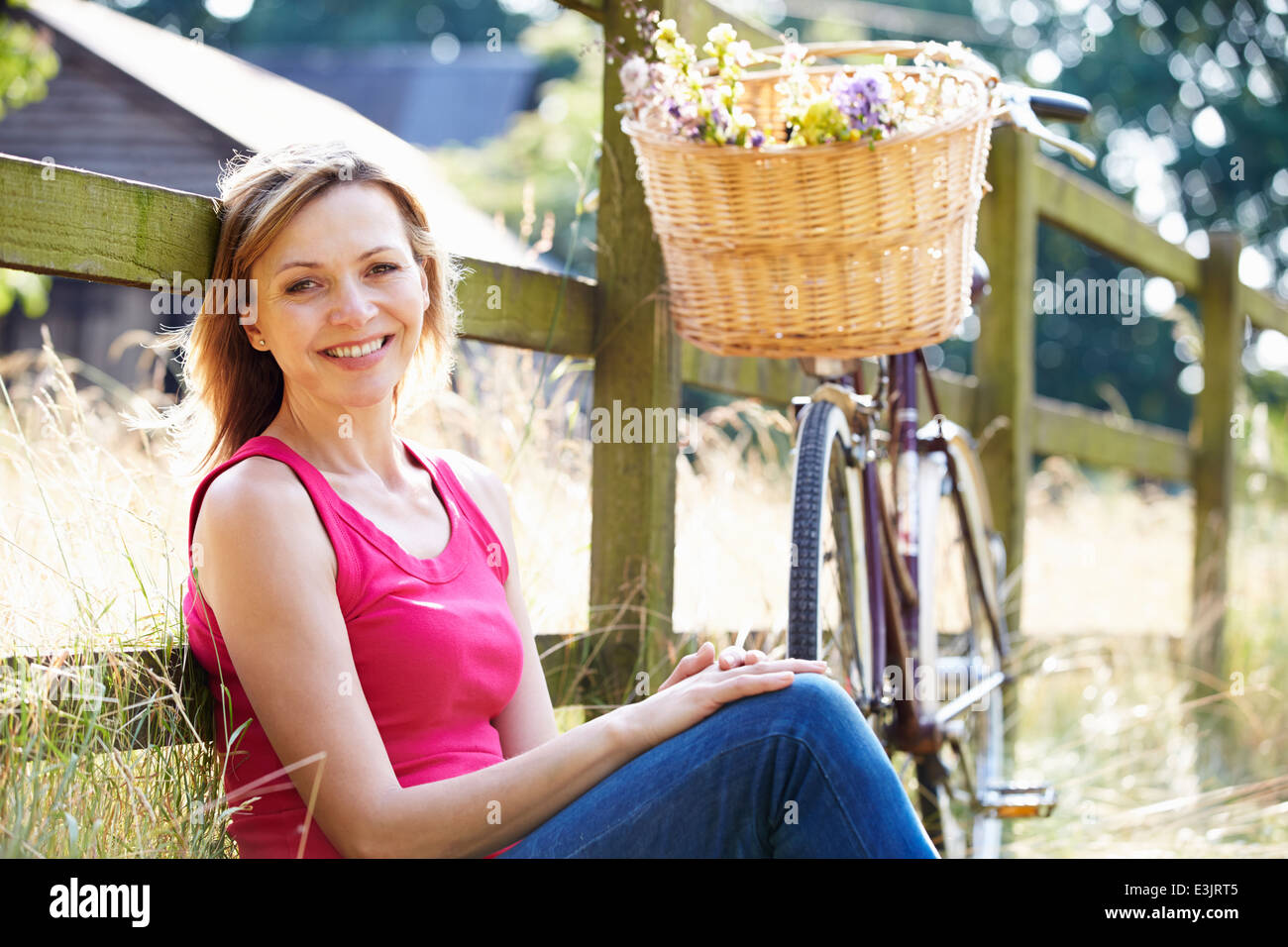 Attraktive Frau entspannend auf Fahrradtour In Landschaft Stockfoto