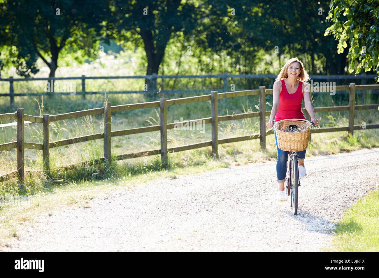Attraktive Frau mit Fahrrad entlang Landstraße Stockfoto