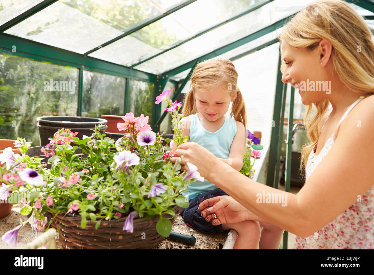 Mutter und Tochter, Anbau von Pflanzen im Gewächshaus Stockfoto