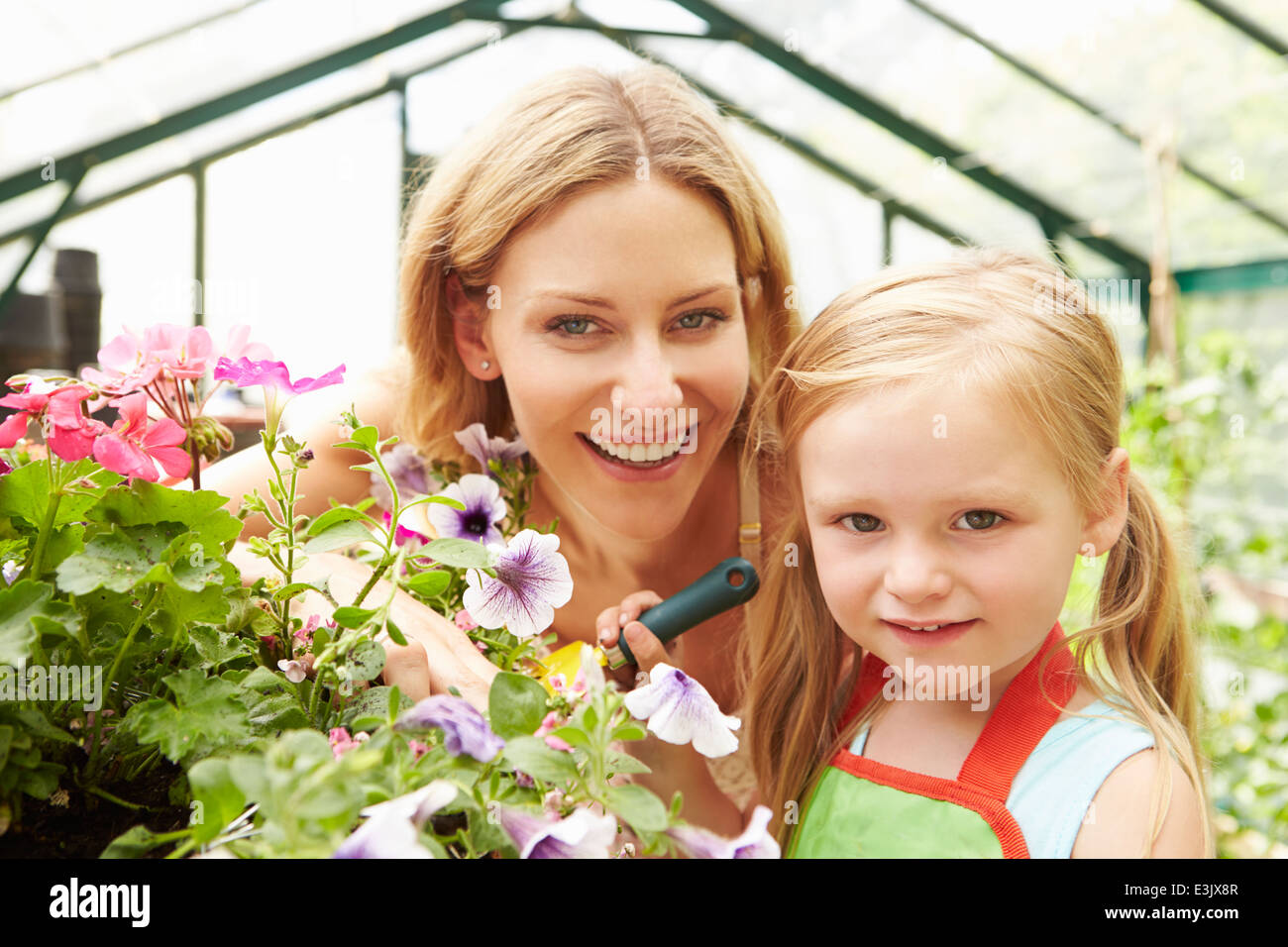 Mutter und Tochter, Anbau von Pflanzen im Gewächshaus Stockfoto