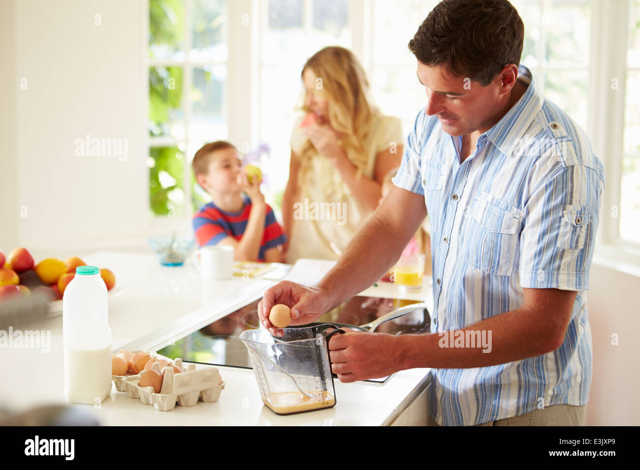 Vater bereitet Frühstück mit der Familie In Küche Stockfoto