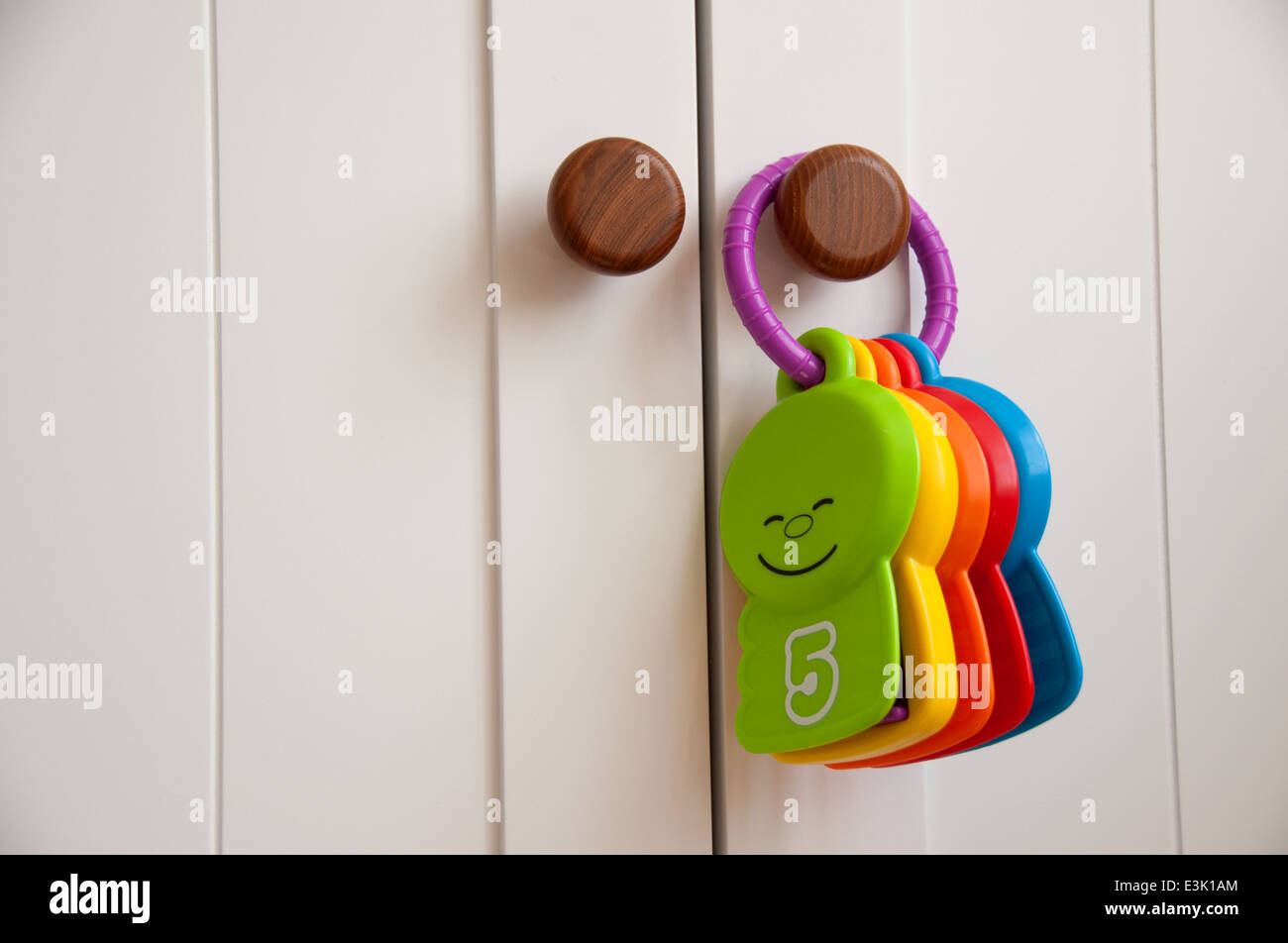 Babys Spielzeug hängen an einem weißen Schrank Tür in der Gärtnerei Stockfoto