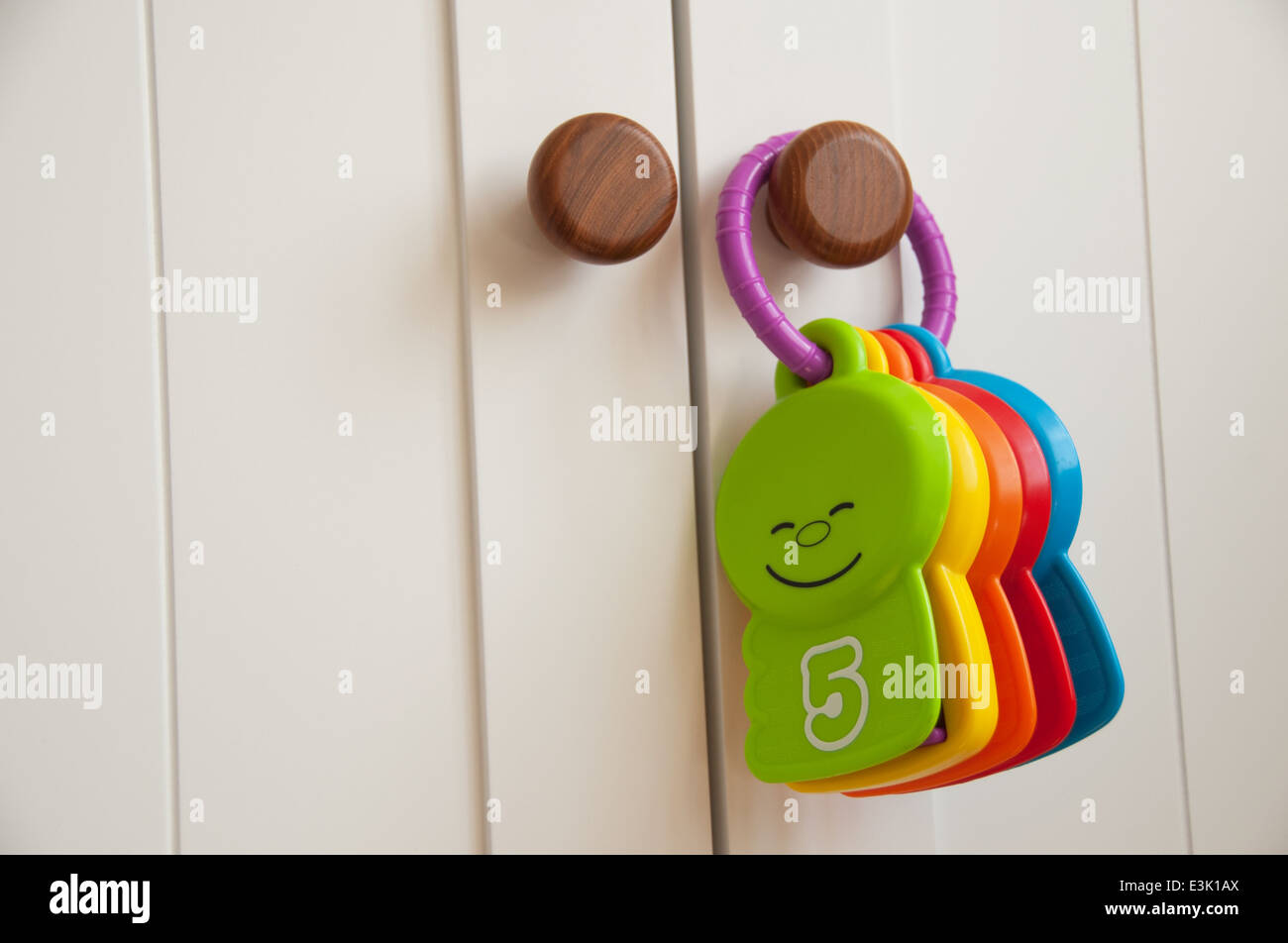 Babys Spielzeug hängen an einem weißen Schrank Tür in der Gärtnerei Stockfoto