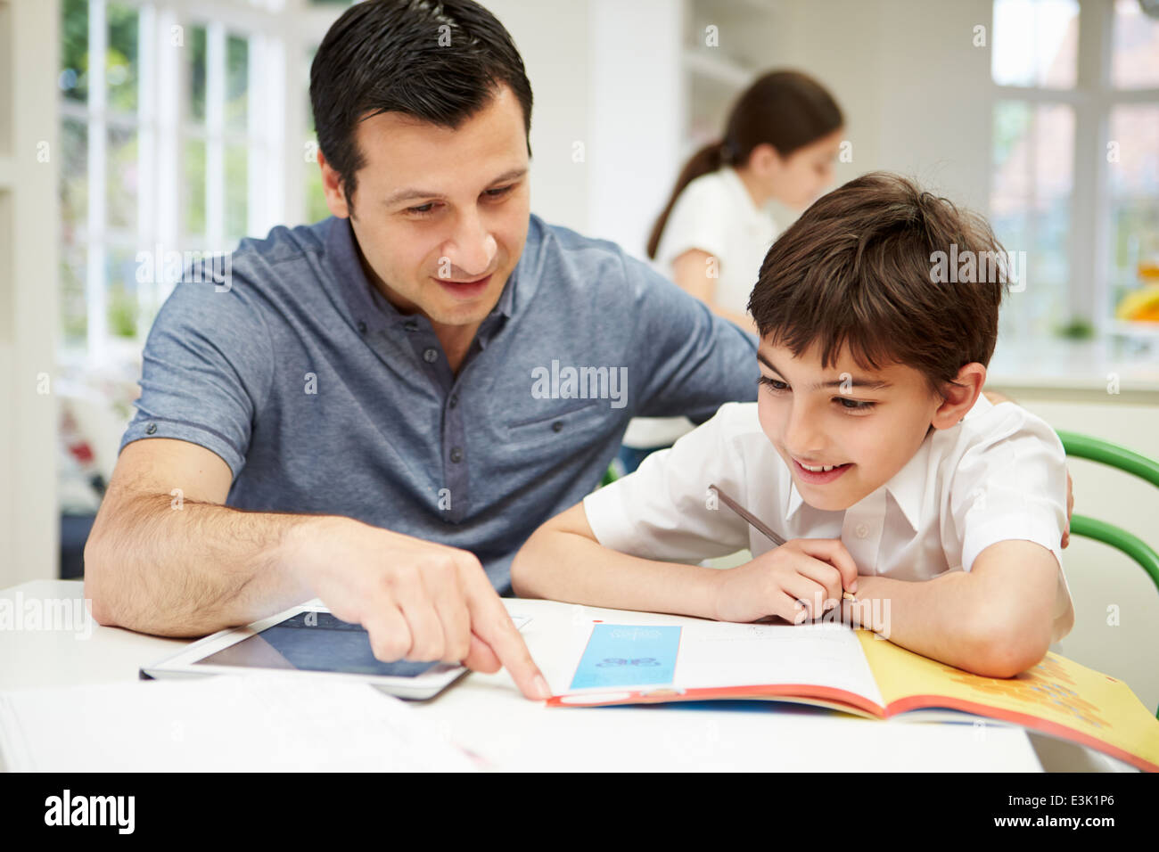 Vater helfen Sohn bei den Hausaufgaben mit Digital-Tablette Stockfoto