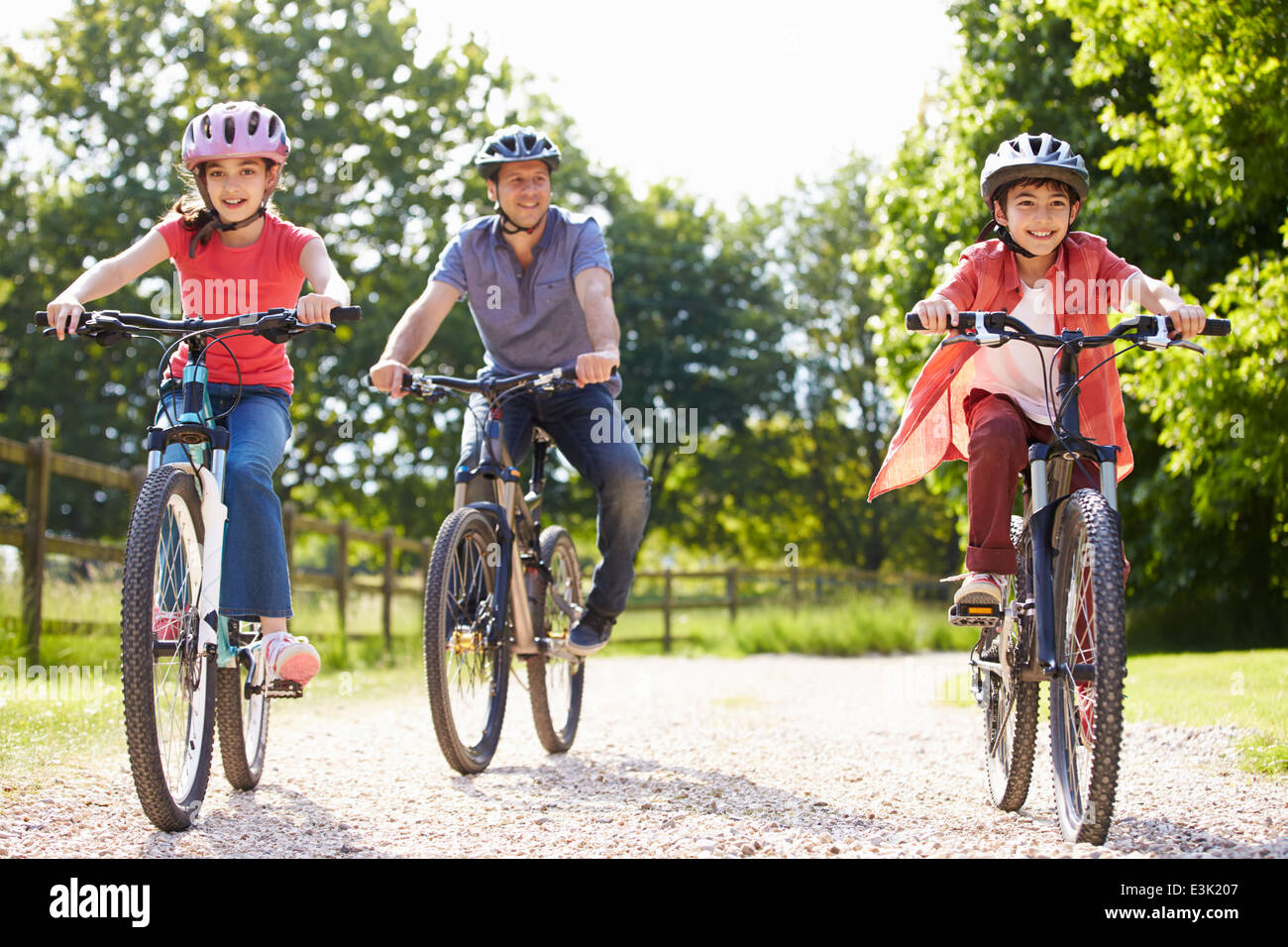 Hispanic Vater und Kinder auf Zyklus fahren In Landschaft Stockfoto