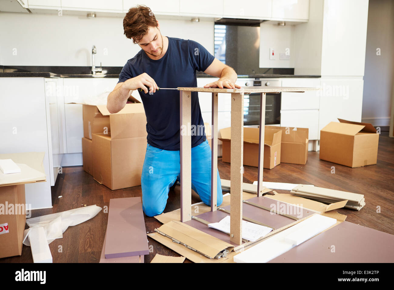 Mann, die Zusammenstellung Selbstmontage Möbel im neuen Zuhause Stockfoto