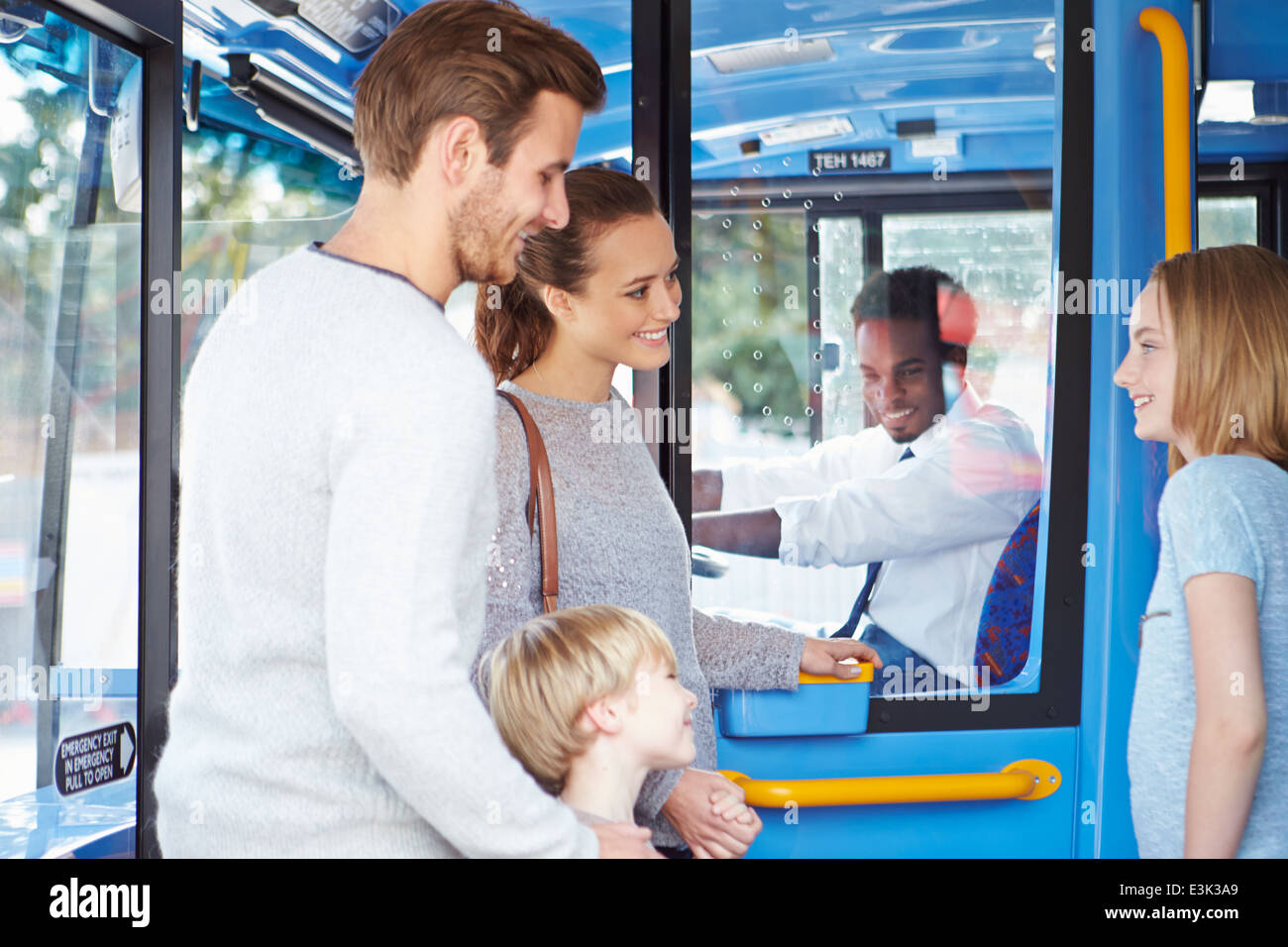 Familie einsteigen in Bus und Ticket kaufen Stockfoto