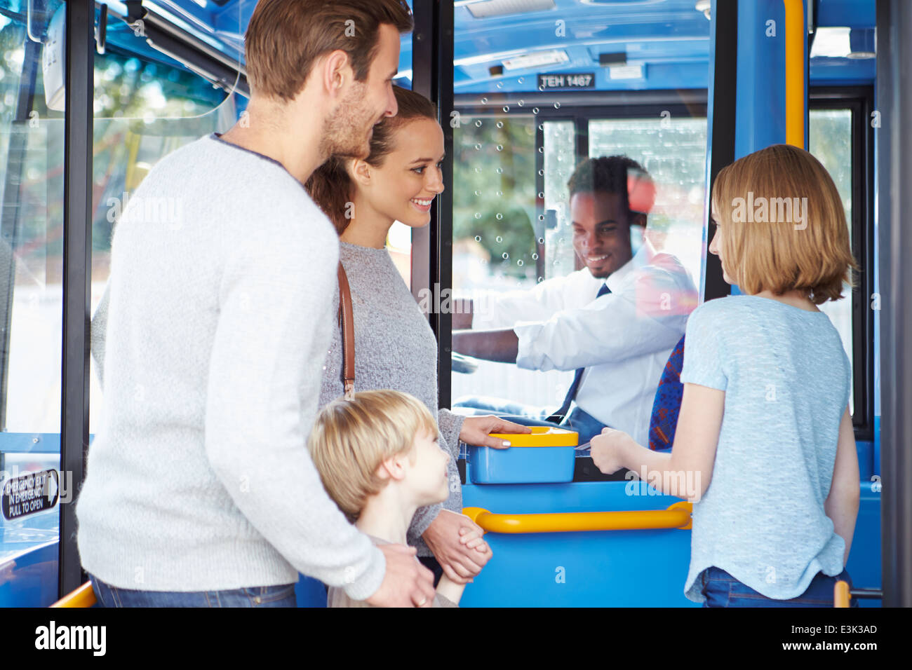 Familie einsteigen in Bus und Ticket kaufen Stockfoto