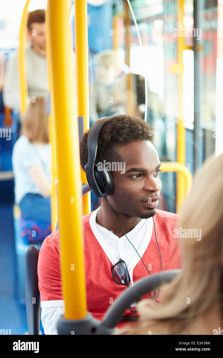 Mann mit Kopfhörern Musik hören auf dem Bus Stockfoto