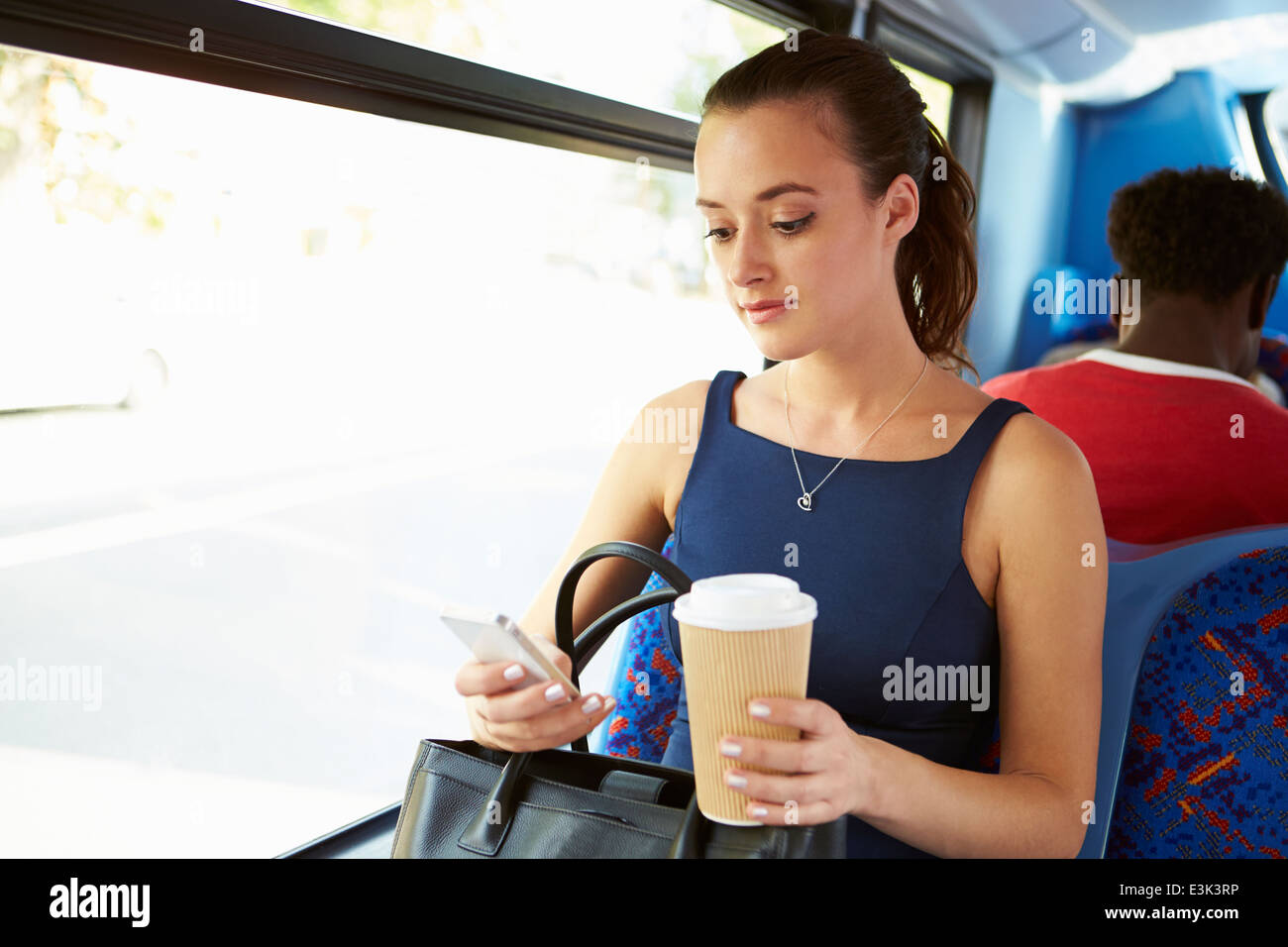 Geschäftsfrau, die SMS auf Bus Stockfoto