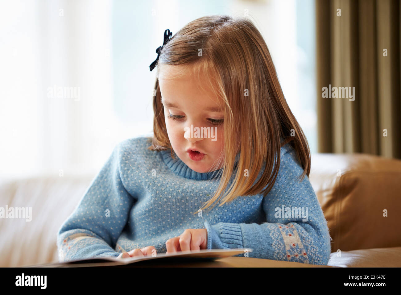 Junges Mädchen lesen Geschichte zu Hause Stockfoto