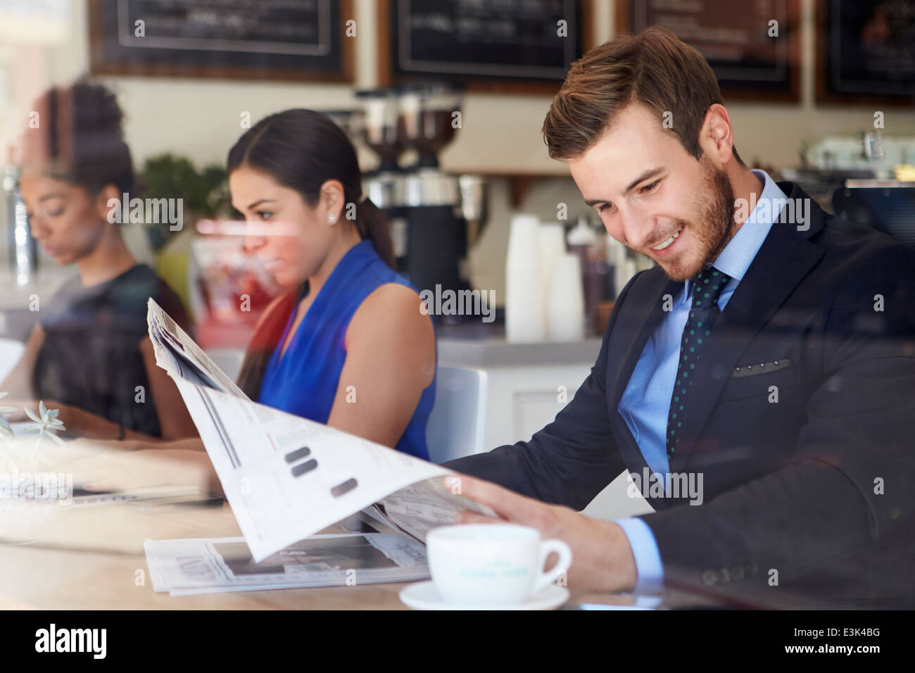 Geschäftsmann lesen Zeitung In Coffee-Shop Stockfoto
