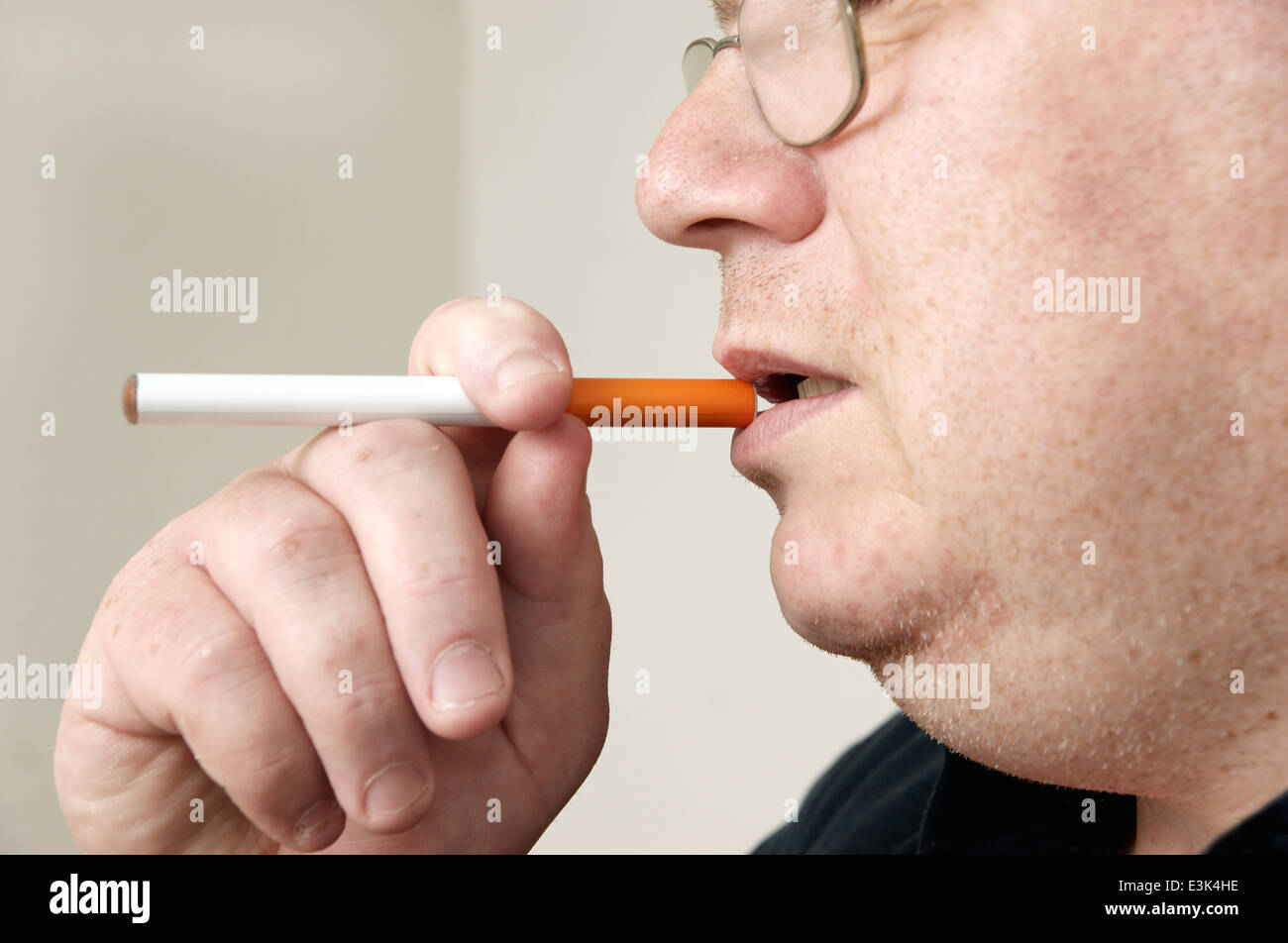 Mann hält & Rauchen eine elektronische Einweg E-Zigarette (e-Zigarette) Stockfoto