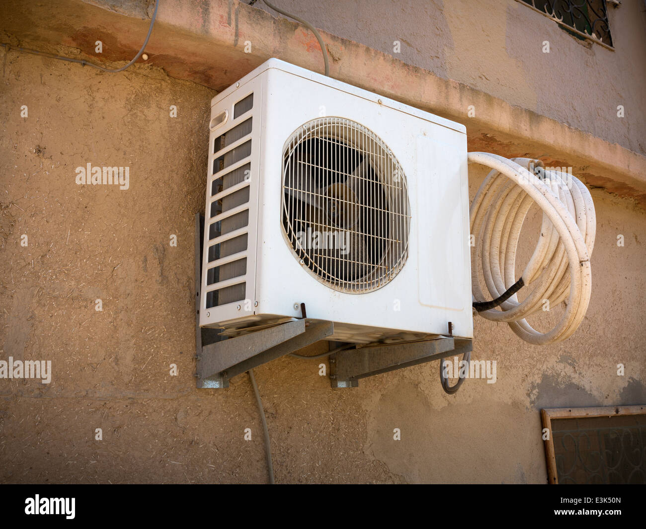 Ein extern montierten Klimaanlage Schrankwand mit einer Spule aus  Kunststoff Schlauch Wandmontage staubigen Lehmziegel-Marokko Afrika  Stockfotografie - Alamy