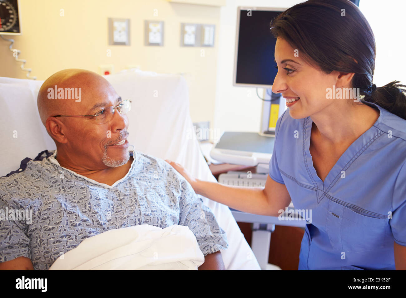 Krankenschwester im Gespräch mit älteren männlichen Patienten im Krankenzimmer Stockfoto