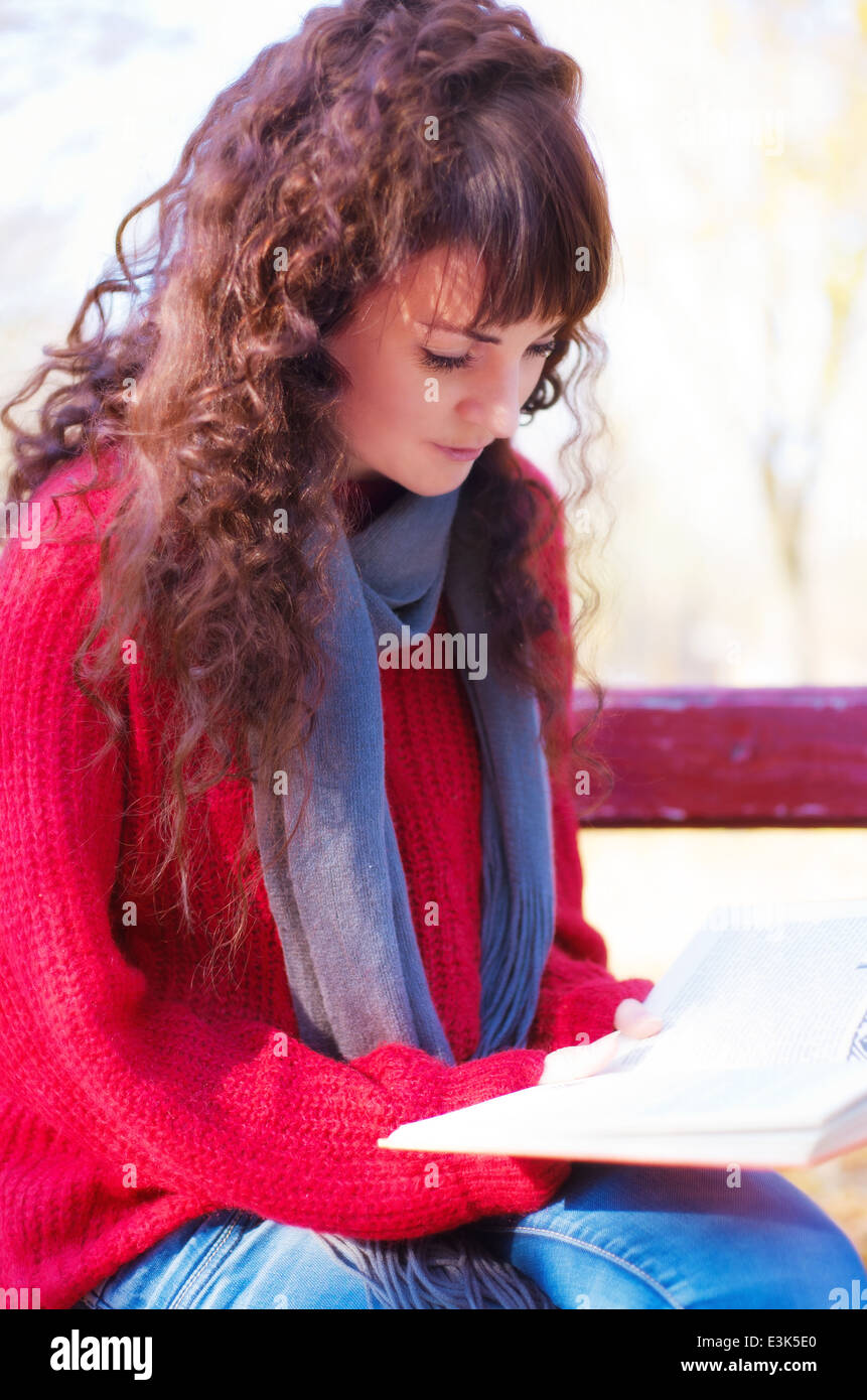 Mädchen Lesen eines Buches im Herbst park Stockfoto