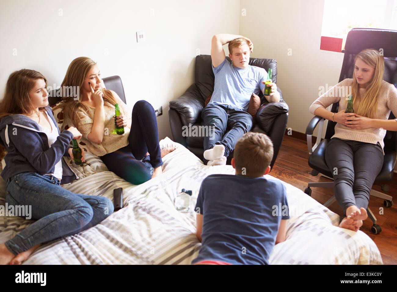 Gruppe von Jugendlichen, die Alkohol In Schlafzimmer Stockfoto
