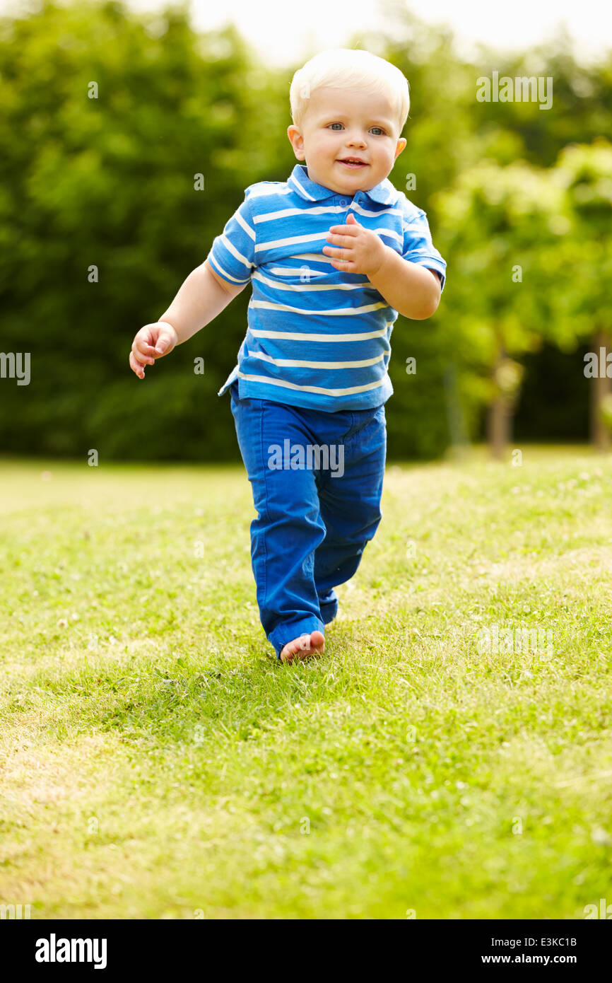 Kleiner Junge spielt im Sommergarten Stockfoto