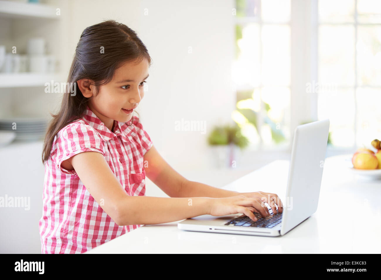 Asiatische Kind mit Laptop zu Hause Stockfoto