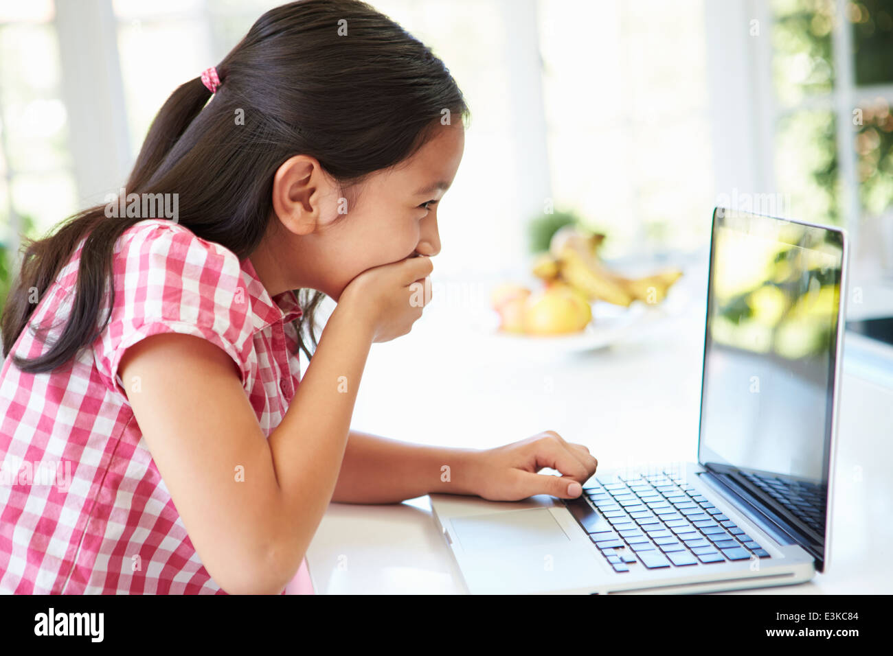 Schockiert asiatischen Kind mit Laptop zu Hause Stockfoto