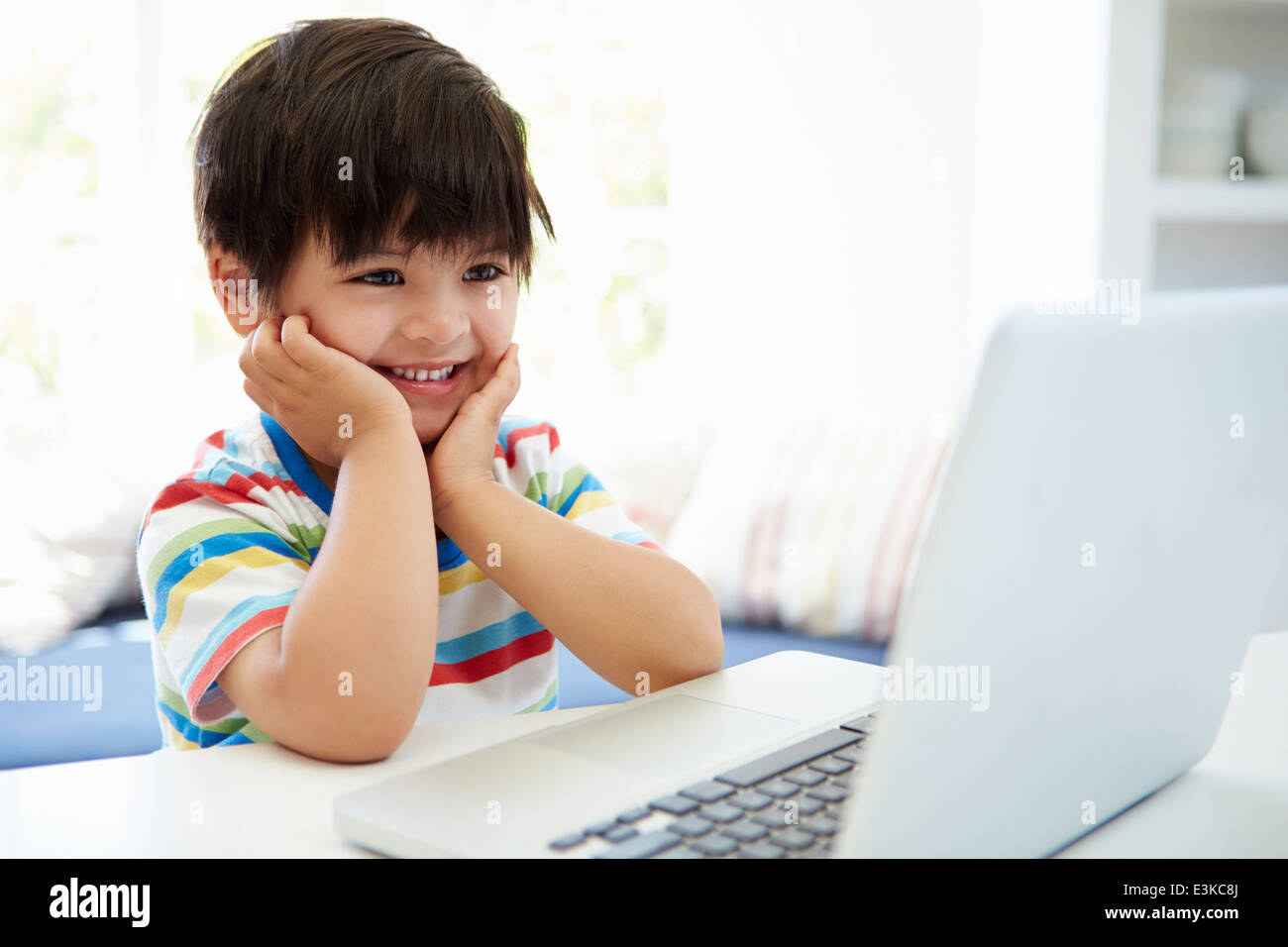 Asiatische Kind mit Laptop zu Hause Stockfoto