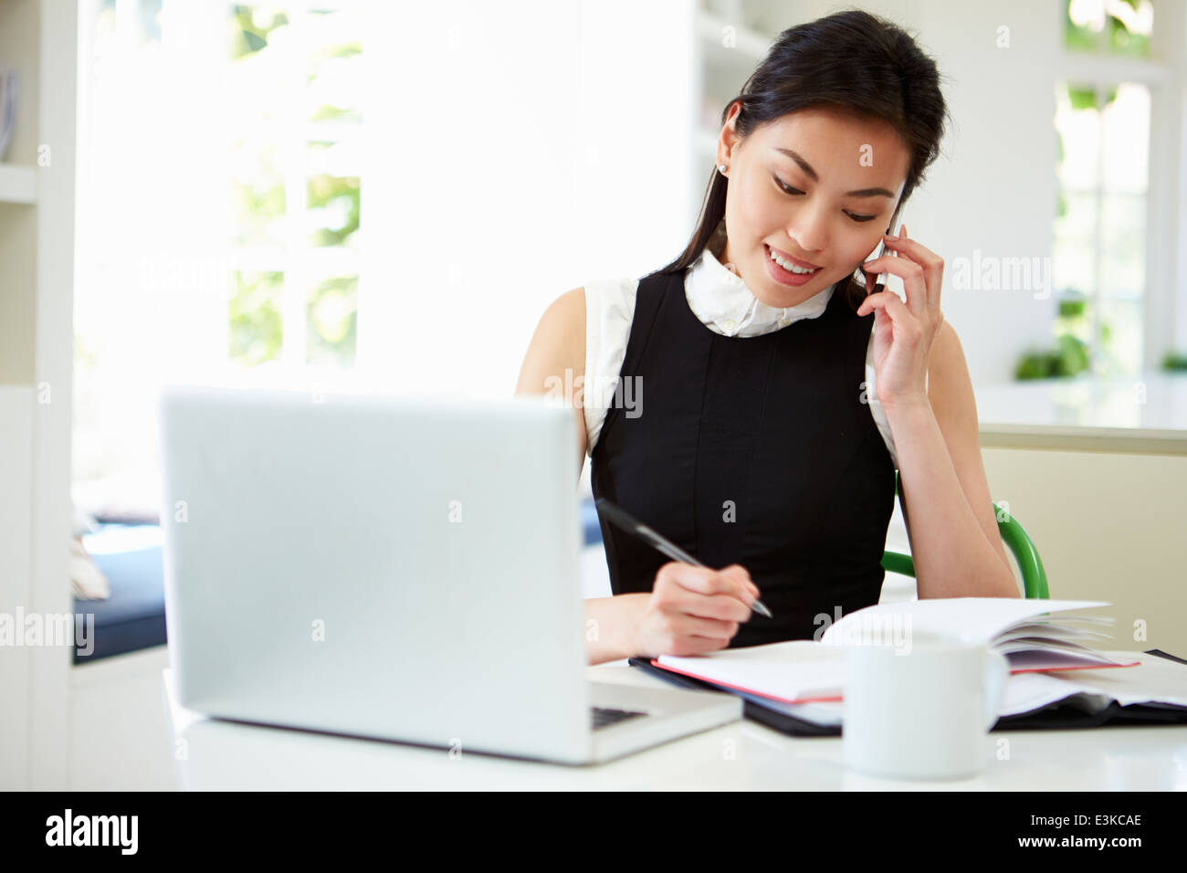 Asiatische Geschäftsfrau Arbeiten von Hause mit Handy Stockfoto