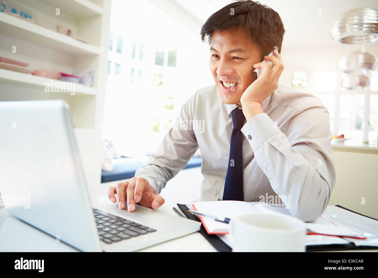 Asiatische Geschäftsmann Arbeiten von Hause mit Handy Stockfoto