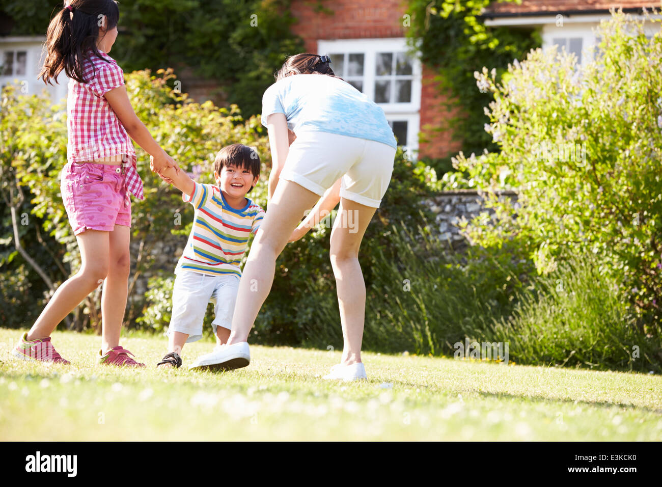 Asiatische Mutter spielen im Sommergarten mit Kindern Stockfoto