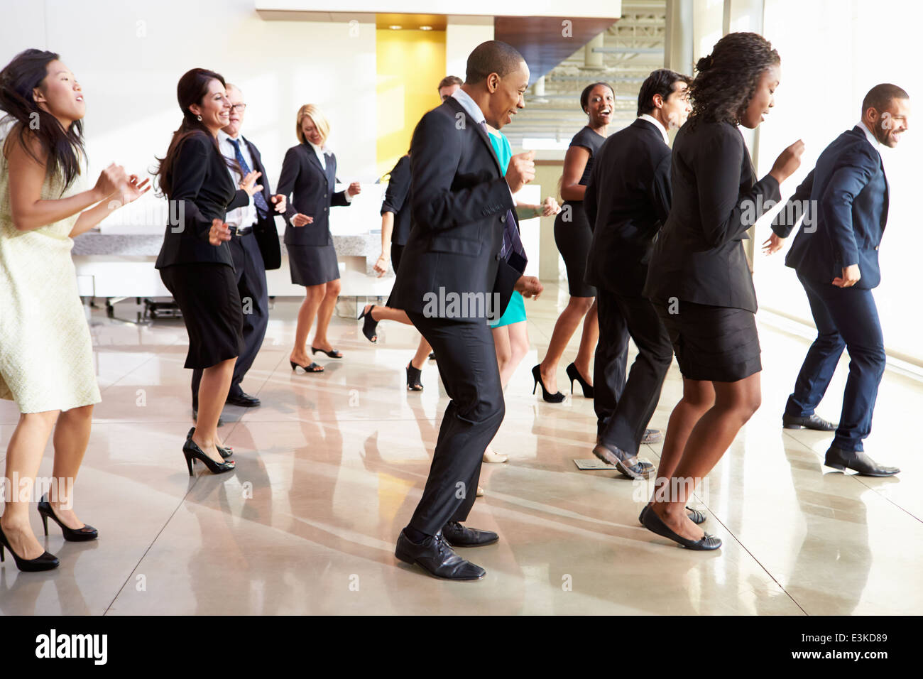Unternehmer und Unternehmerinnen im Büro Lobby tanzen Stockfoto
